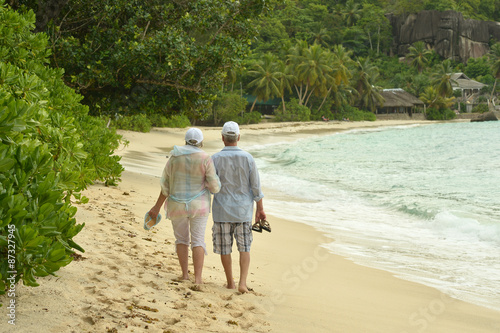  elderly couple walking along the seashore