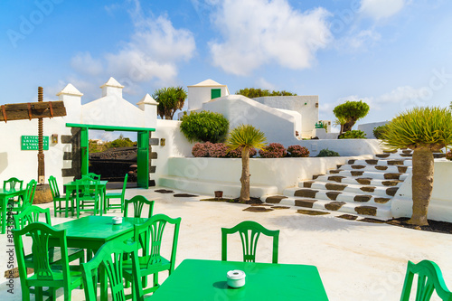 Green tables with chairs in typical Canarian style village, El Campesino Monumento, Lanzarote island, Spain photo