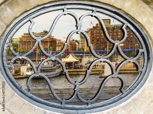 Oval window with forged lattice. Reflection of Stockholm in glass