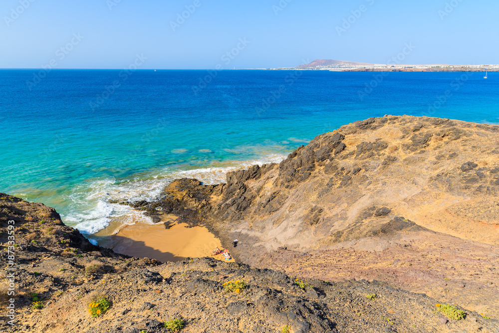 Couple of people sunbathing on Papagayo beach, Lanzarote, Canary Islands, Spain