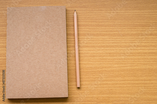 Note book with pencil on a wooden desk