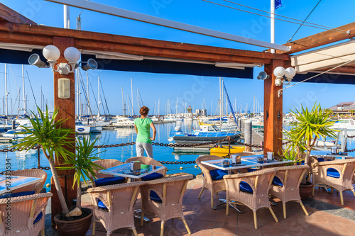 Young woman tourist standing in restaurant in Rubicon yacht port, Lanzarote, Canary Islands, Spain