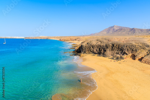 Couple of people in turquoise ocean water on Papagayo beach  Lanzarote  Canary Islands  Spain