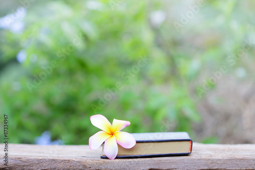 Notebook and flower on wooden table