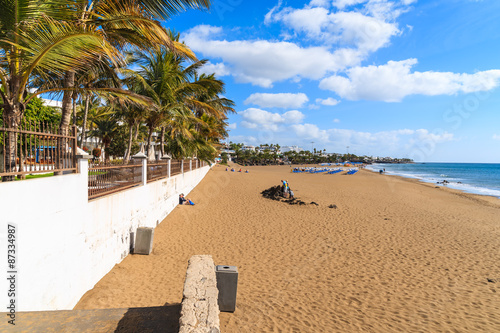 Sandy tropical beach with palm trees in Puerto del Carmen, Lanzarote, Canary Islands, Spain