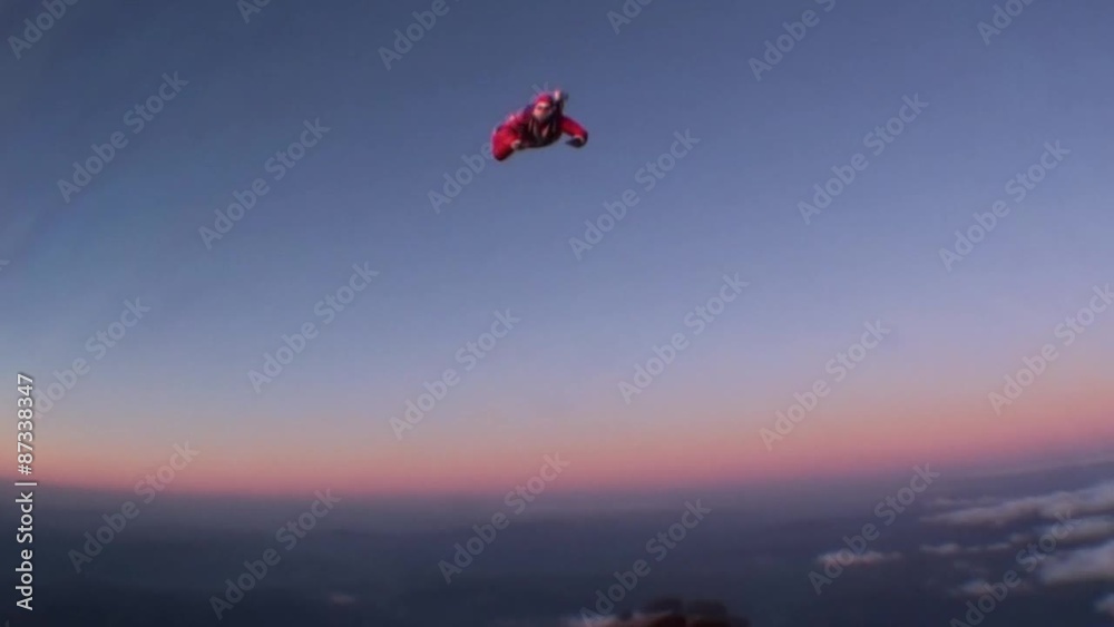 Skydiving Santa Claus jumping with a parachute at a sunset. Winter.