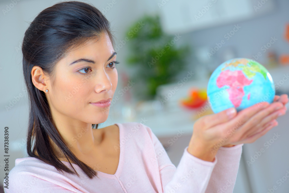 Woman holding a miniature globe Woman holding a miniature globe