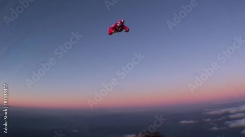Skydiving Santa Claus jumping with a parachute at a sunset. Winter. photo
