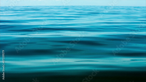 Blue calm sea water background with gently moving waves creating a relaxing atmosphere