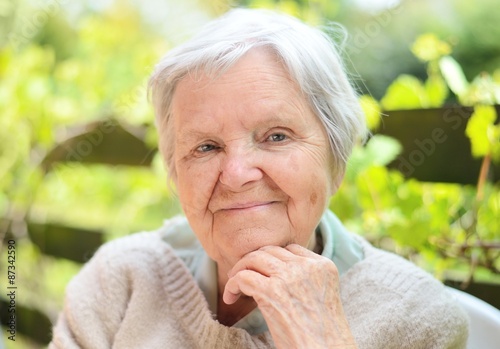 Obraz na płótnie Senior woman smiling and dreaming in garden. w salonie