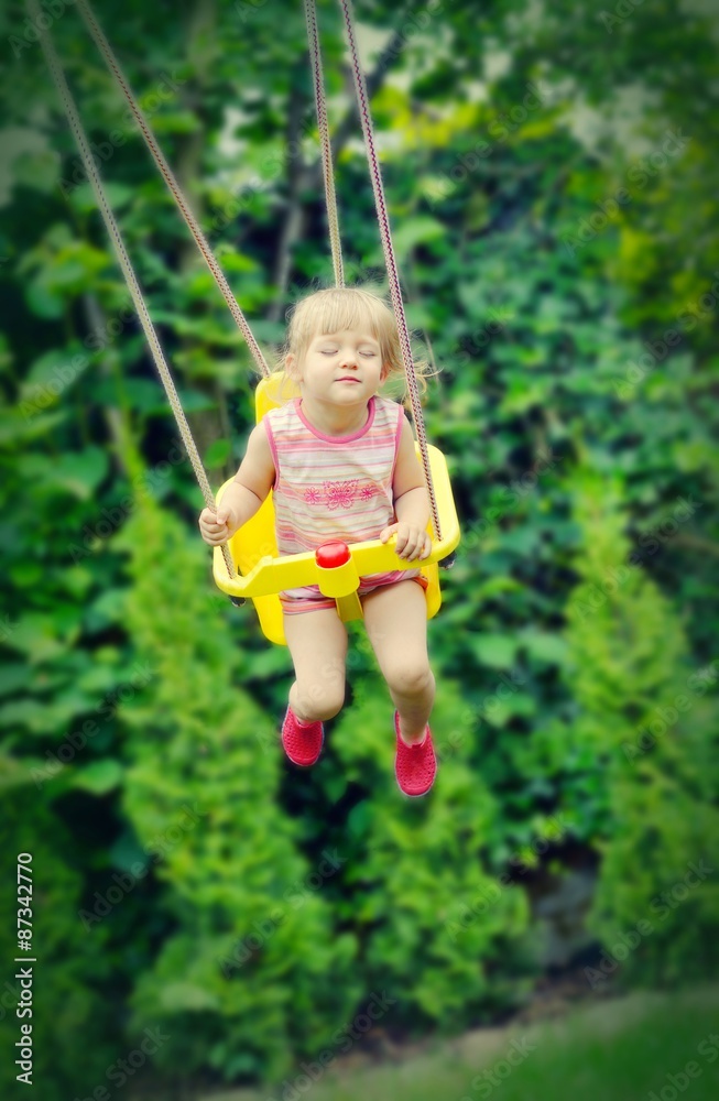 Cute little girl swings. Outdoors scenery. Cute little girl swings. Outdoors scenery.