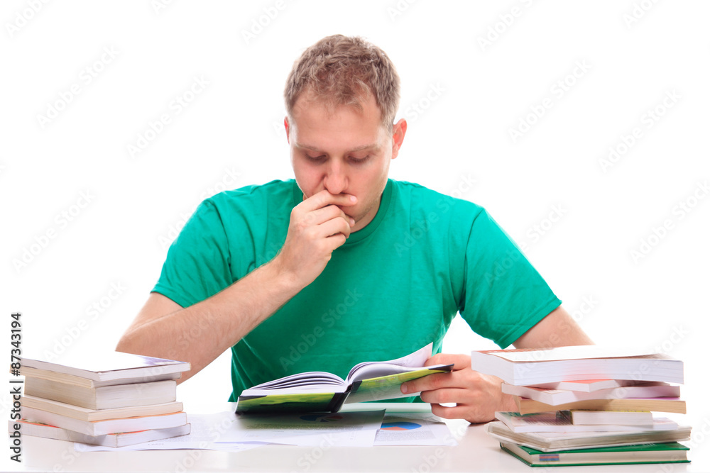 Young man reading literature at the desk Young man reading literature at the desk