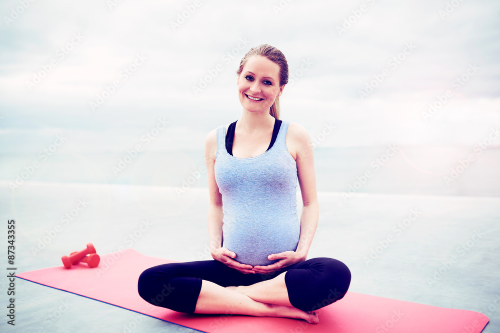 Happy woman keeping fit during her pregnancy Happy woman keeping fit during her pregnancy
