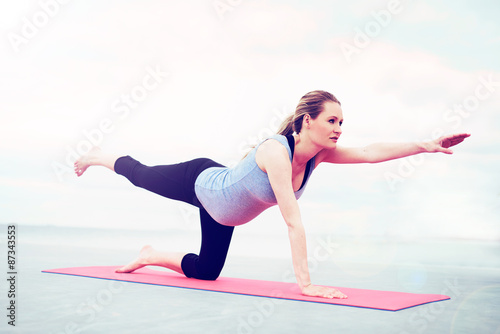 Young pregnant woman practicing pilates