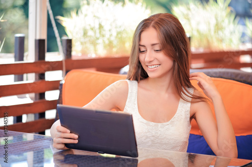 Free Download Smiling woman using tablet in cafe - GFXLoad
