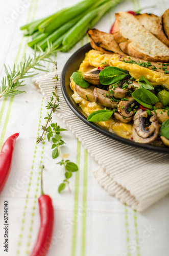 Omelet with mushrooms, lamb's lettuce, herbs and chilli