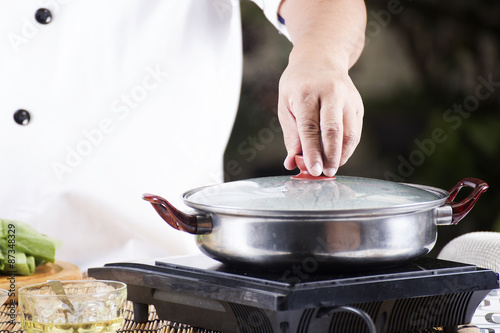 Chef opening the lid of pot before cooking noodle