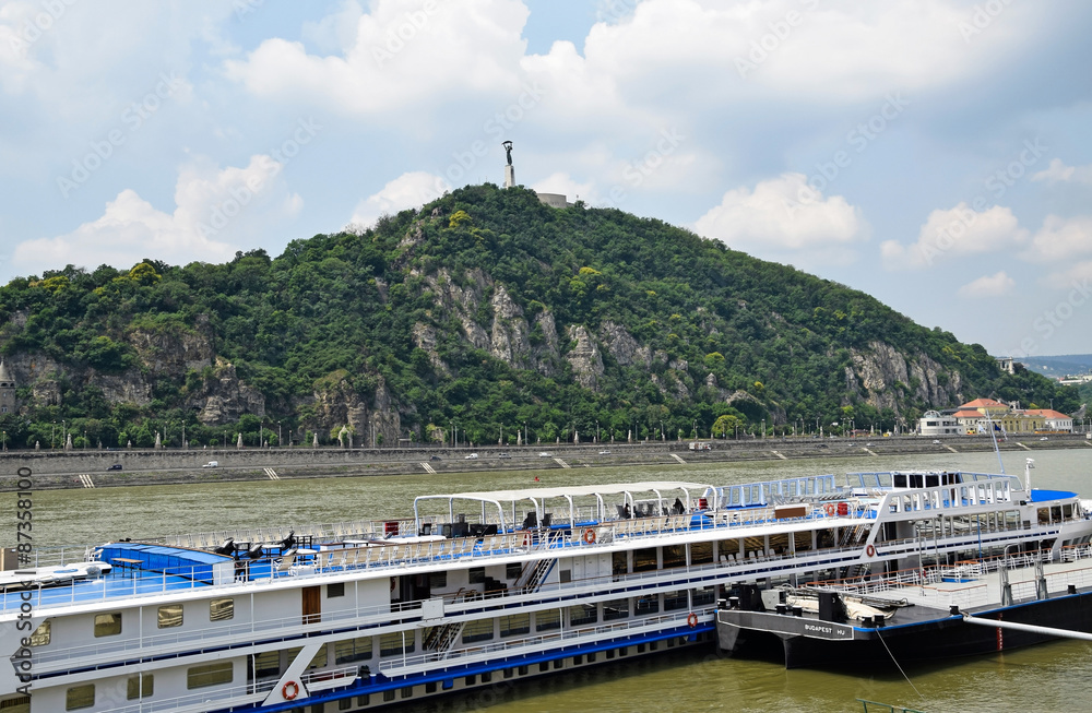 The Gellért hill and a tourist ship in Budapest city, Hungary