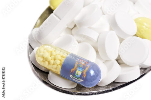 Spoon full of pills and a capsule with the flagdesign of Michiga photo