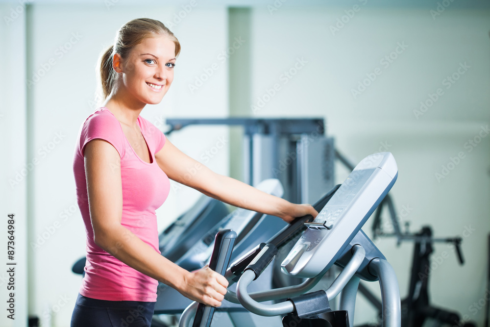 Woman exercising on treadmill in gym Woman exercising on treadmill in gym
