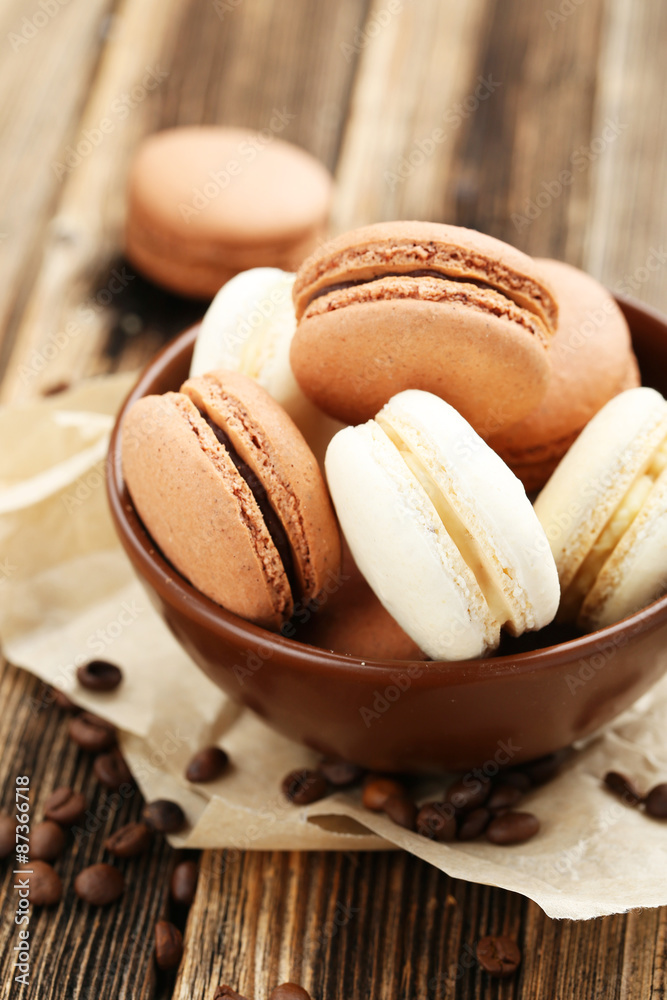 Coffee macarons with coffee beans on brown wooden background Coffee macarons with coffee beans on brown wooden background