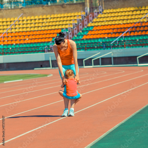 Mother & little daughter running around the stadium. Child runs away from mom at the stadium. © ruslimonchyk
