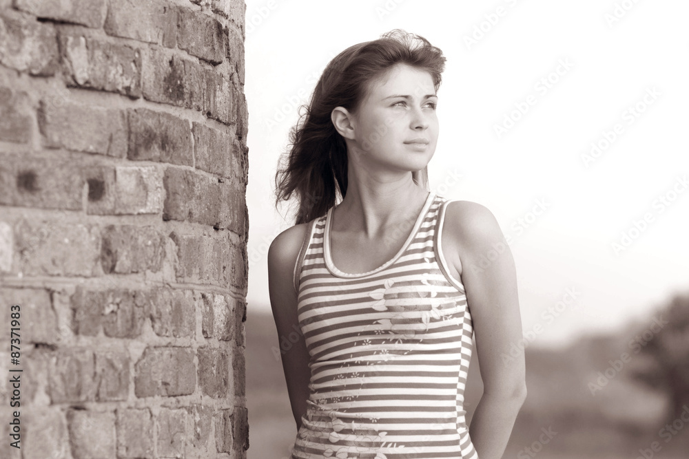 beautiful girl near a brick abandoned building