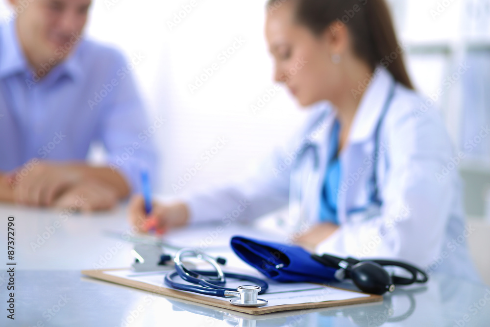 Fototapeta premium Doctor woman sitting with male patient at the desk
