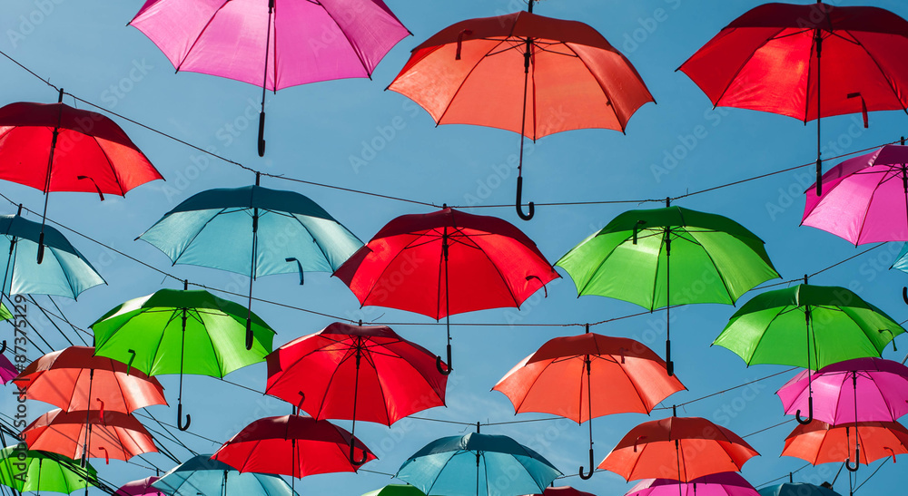 Streets are decorated with colorful umbrellas.
