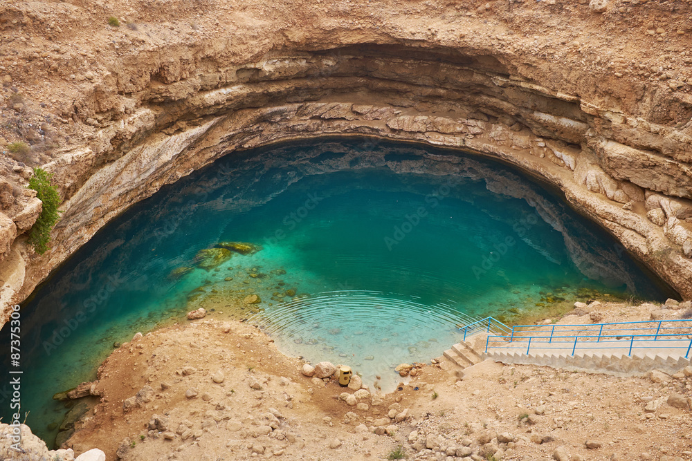 Sinkhole with emerald green water at Hawiyat Najm Park, Oman