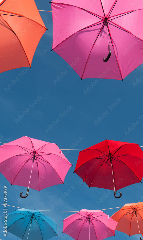 Streets are decorated with colorful umbrellas.
