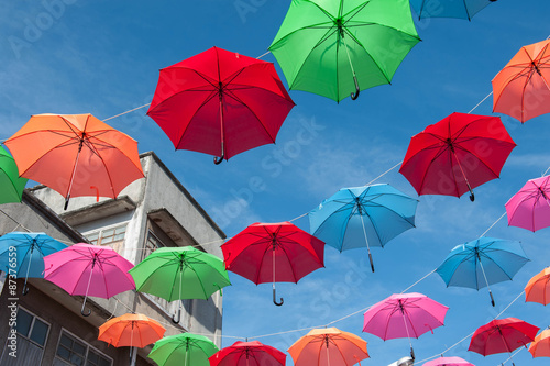Streets are decorated with colorful umbrellas. 