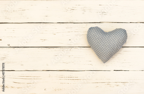 Blaues Herz mit weißen Punkten auf Holzhintergrund