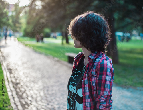 Lonely teenage girl standing in a park