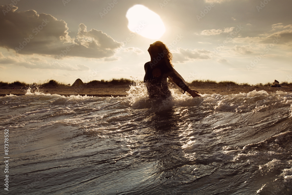 Fototapeta premium Young woman on sea embracing the the world and the waves