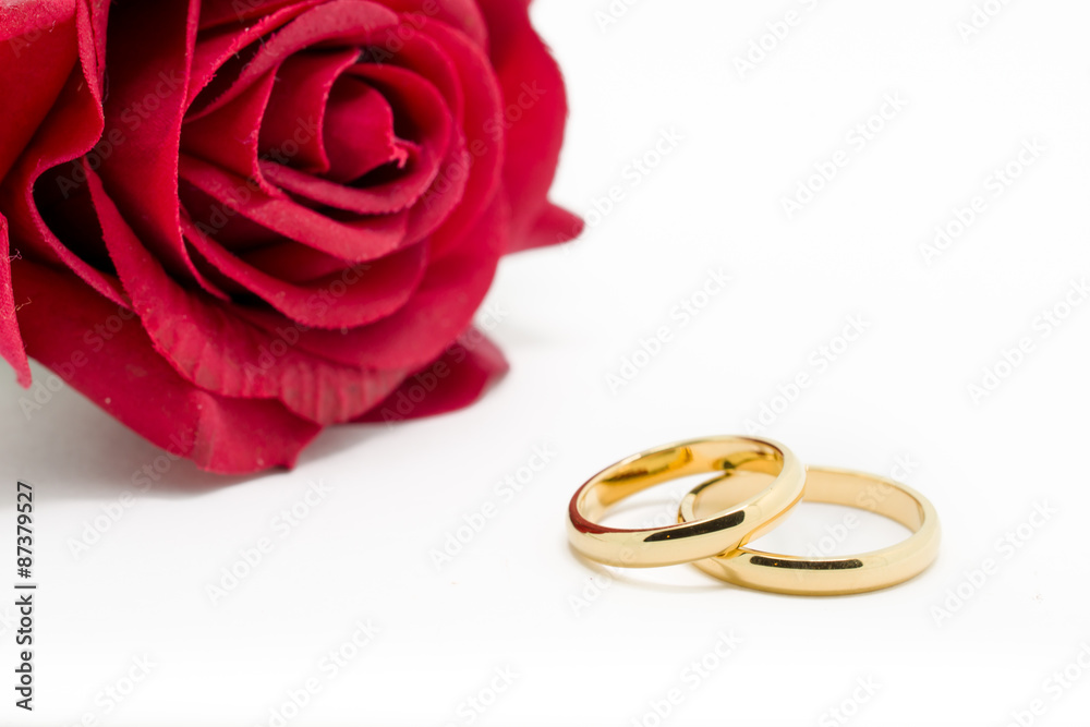 Wedding rings and artificial rose on white background Wedding rings and artificial rose on white background