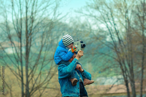 Grandfather teaches his grandson to photograph vintage camera. Grandfather and grandchild.