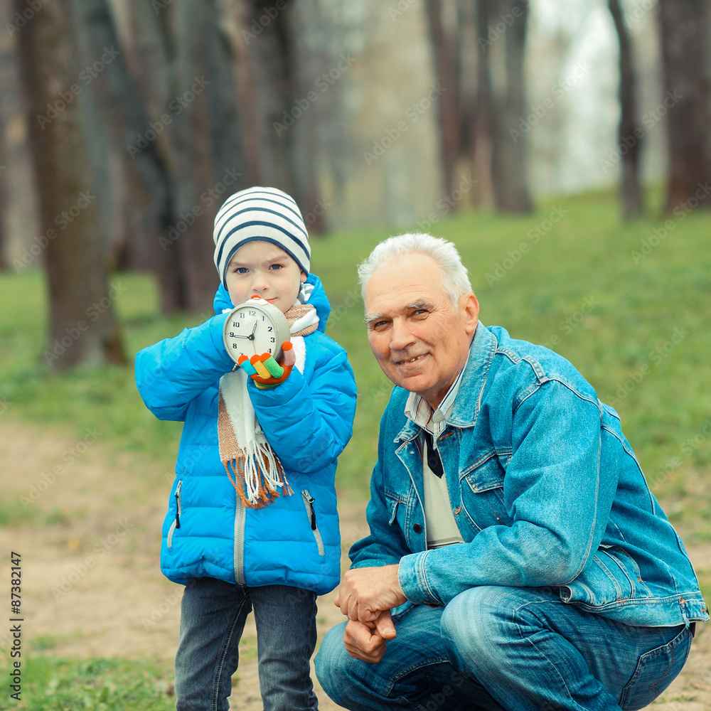 Fototapeta premium Grandfather showing grandson vintage watches. The grandfather tells his grandson about time.