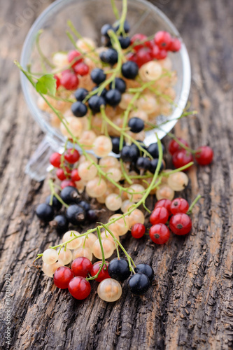 Currants in a transparent cup on the old wooden table