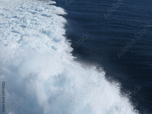 Blue sea water splash in trace of ship