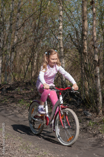 little girl rides a bicycle