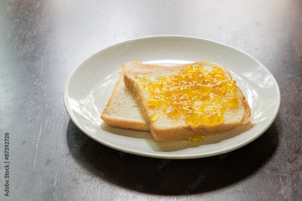Bread with orange jam on wooden table Bread with orange jam on wooden table