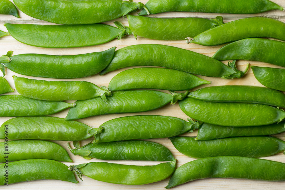 pea pods on a wooden surface