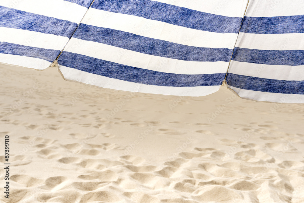 Lonely white and blue strip umbrella on the beach. Shallow depth of field Lonely white and blue strip umbrella on the beach. Shallow depth of field