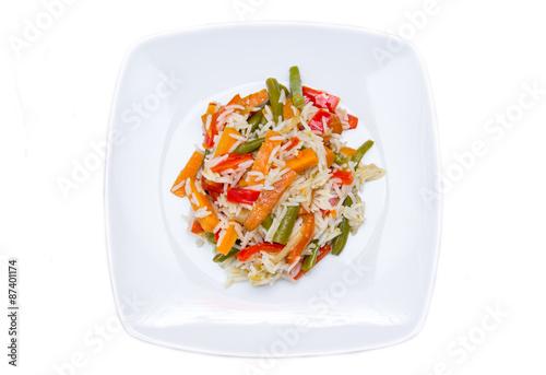 Rice with sauteed vegetables on a white background seen from above
