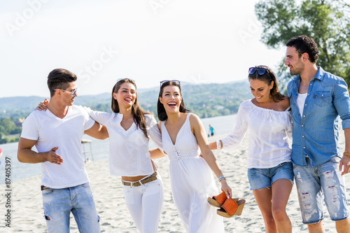 Group of young people holding hands on beach