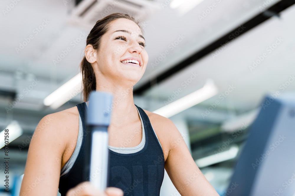 Beautiful young lady using the elliptical trainer Beautiful young lady using the elliptical trainer