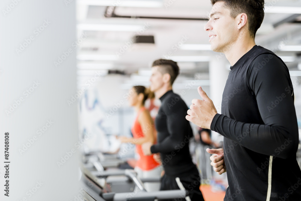 Group of young people using treadmills in a gym Group of young people using treadmills in a gym
