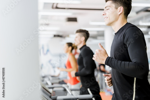 Group of young people using treadmills in a gym