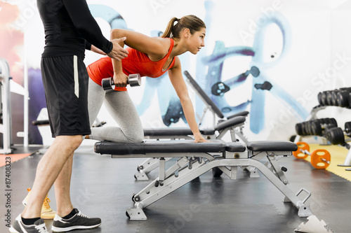 Fotografie Young male trainer giving instructions to a woman in a gym
